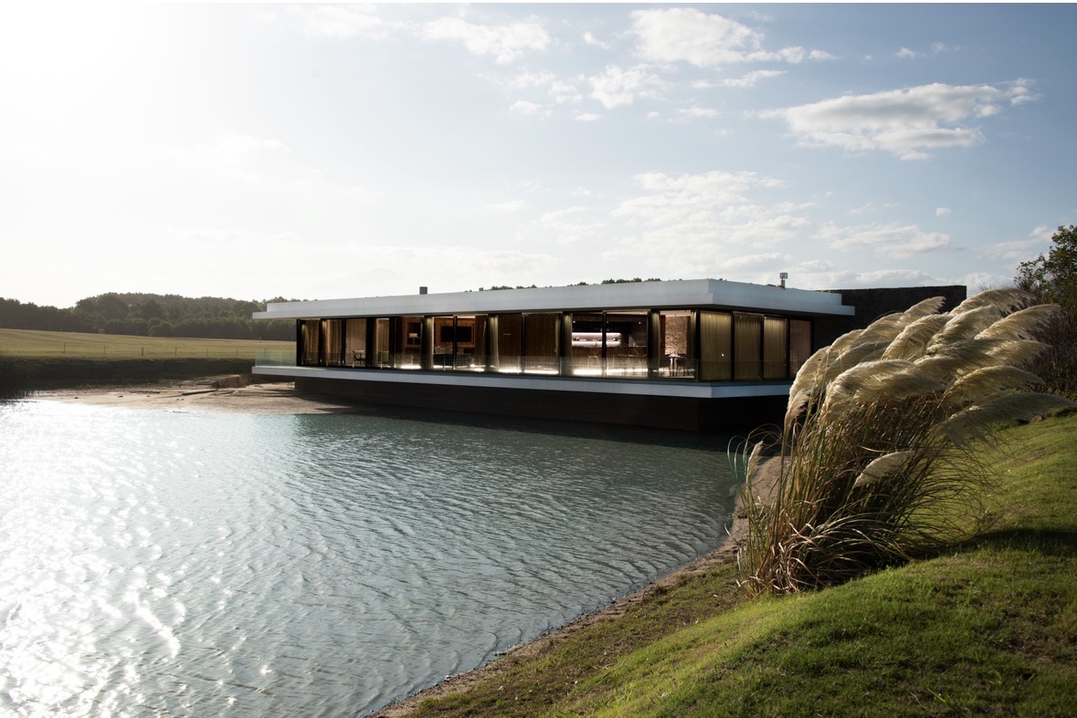 Beach House de Las Cárcavas, arquitectura moderna emplazada sobre la laguna y frente al mar al atardecer